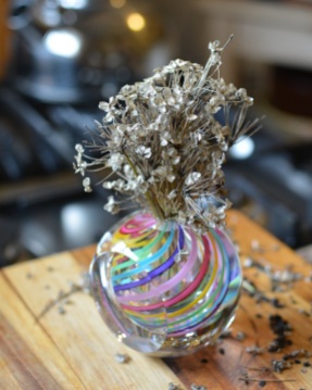 dried garlic chive flowers in a colored glass vase Feb 9 2019